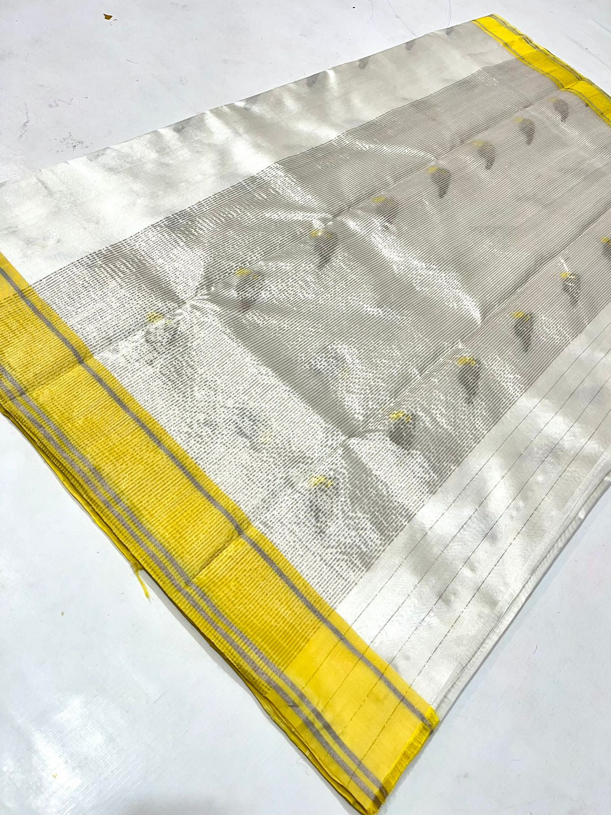 White Kerala Pattu Tissue Saree with Elephant Motifs and Yellow Border