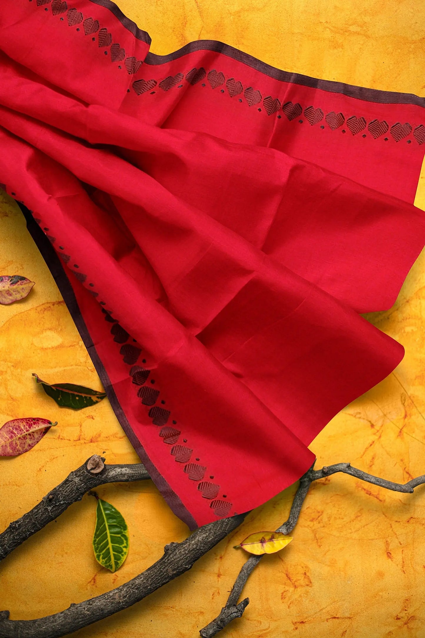 A red khadi cotton saree with a traditional love weaving pattern on the border. The saree is made of 100% cotton. Putul's fashion