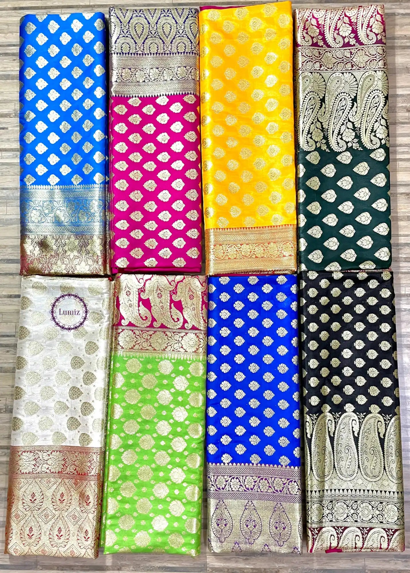 Collection of colorful silk sarees with traditional Banarasi patterns and polka dot designs.